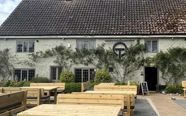 The outside of a country pub with outdoor seating