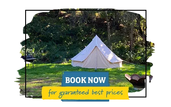 a bell tent in an open field, with a fire pit and a grill