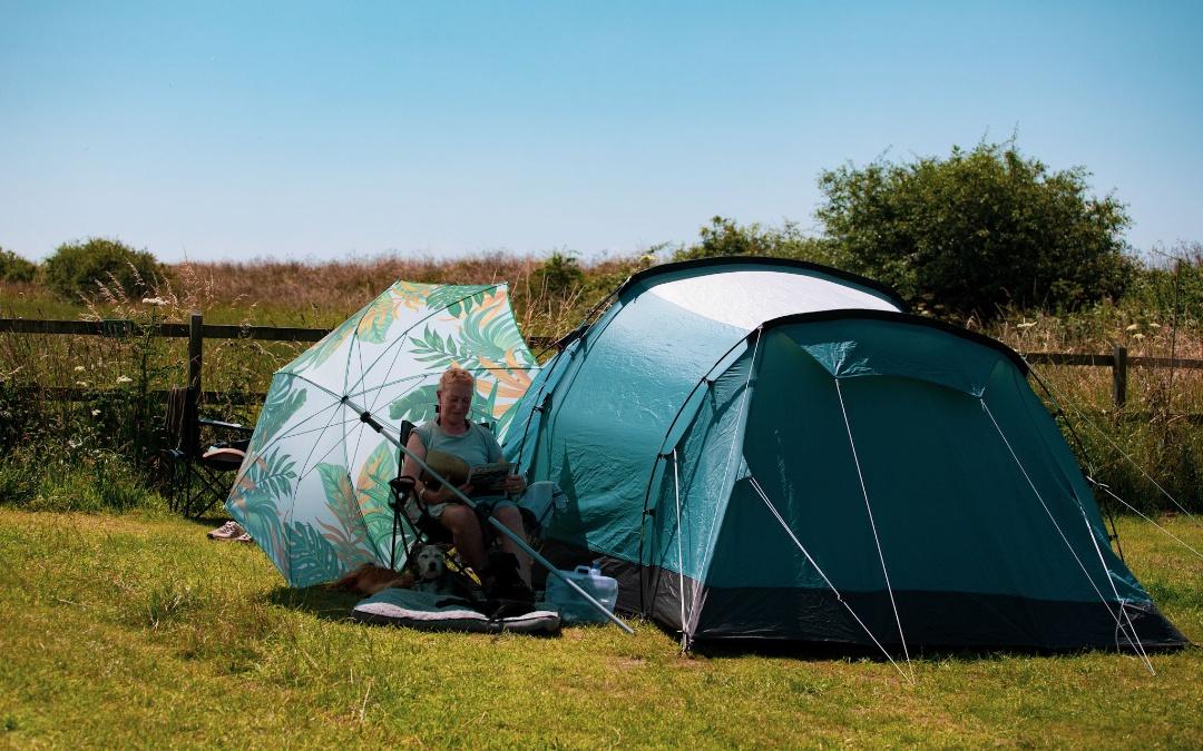 Camping hunstanton: A girl reading a book next to a tent