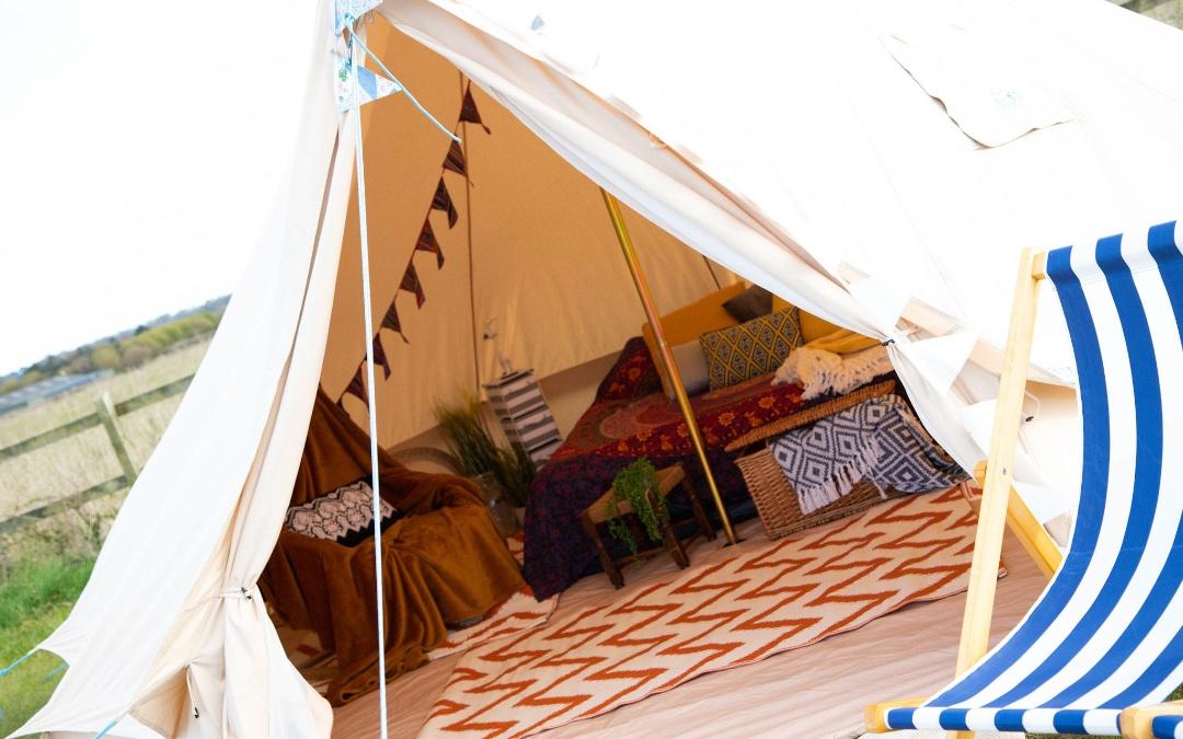 west of wells camping & glamping, glamping bell tent with view inside to soft furnishings and double bed