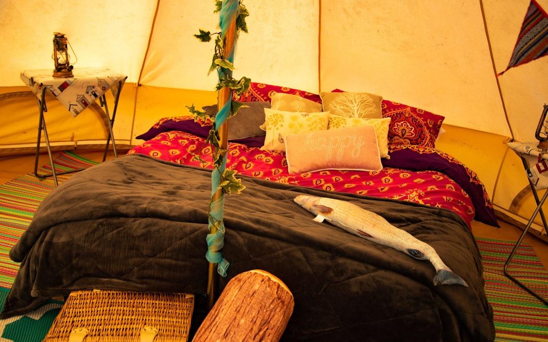west of wells camping & glamping, inside glamping bell tent with double bed and camping tables