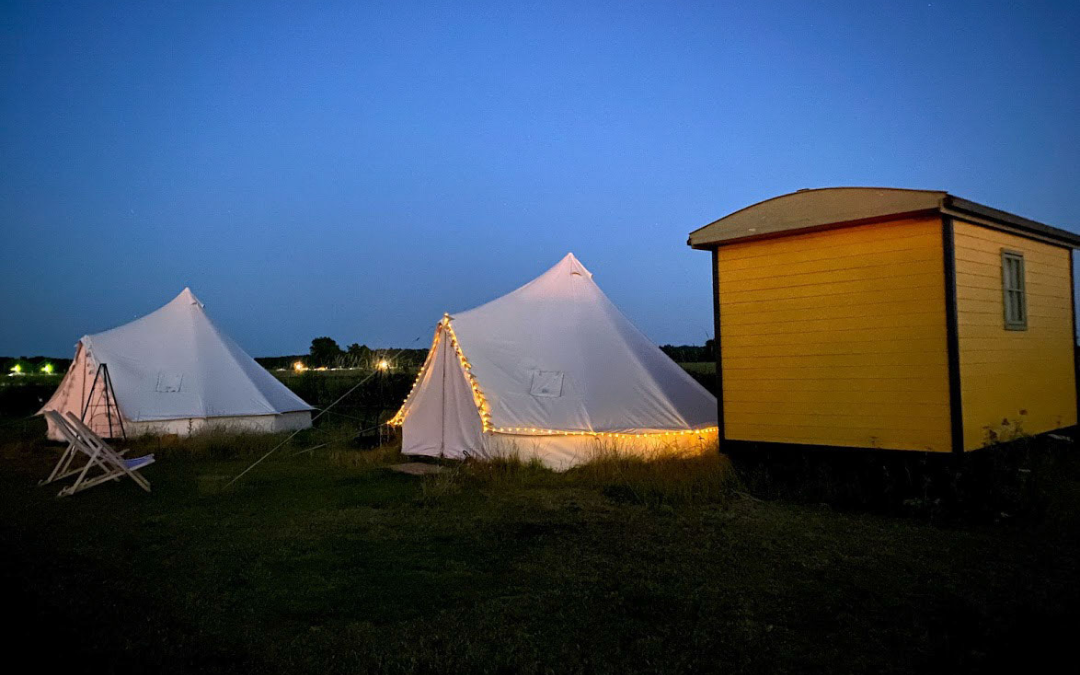 mYminiBreak, Hunstanton Glamping, bell tents and shepherds huts lit up for an evening under the stars