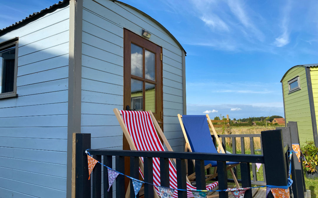 our glamping shepherds huts have deck chairs for relaxing and watching a stunning sunset with your loved one
