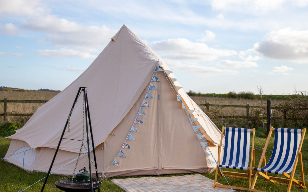 Blank canvas bell tent with outside seating and firepit here at Hunstanton Glamping