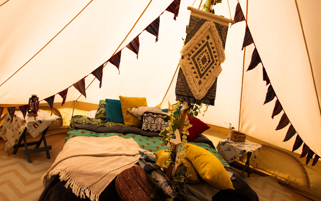An inside look at our glamping bell tents, big comfy bed with lovely textiles here at Hunstanton Glamping