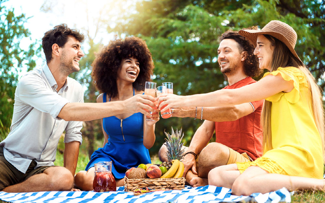 group of friends sharing drinks at a picnic