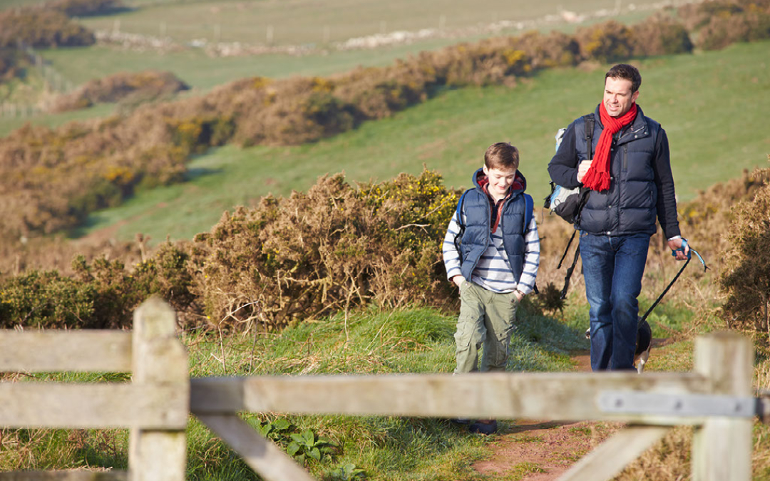 father and son walking norfolk coast path fields