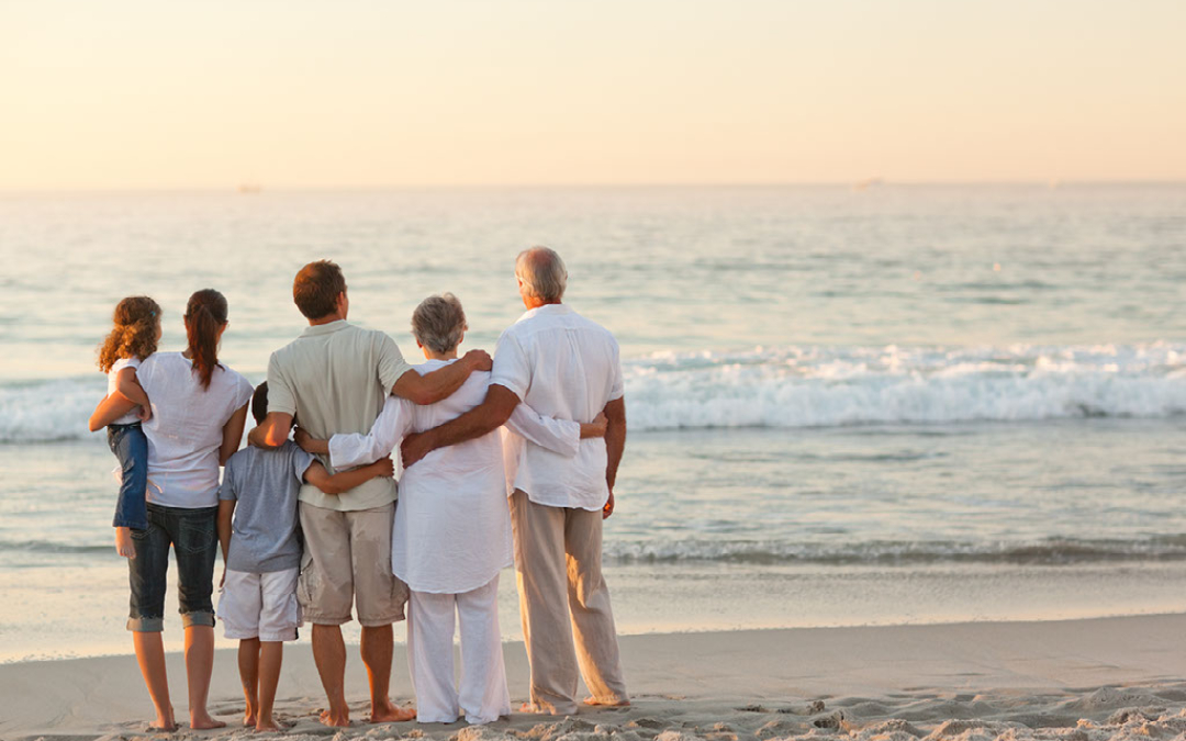 family on the beach looking out to sea