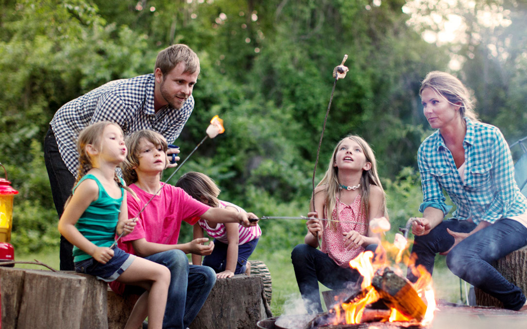 family roasting marshmallows campfire fire pit