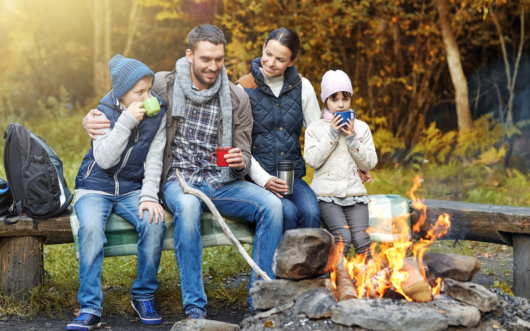 young family sitting around campfire