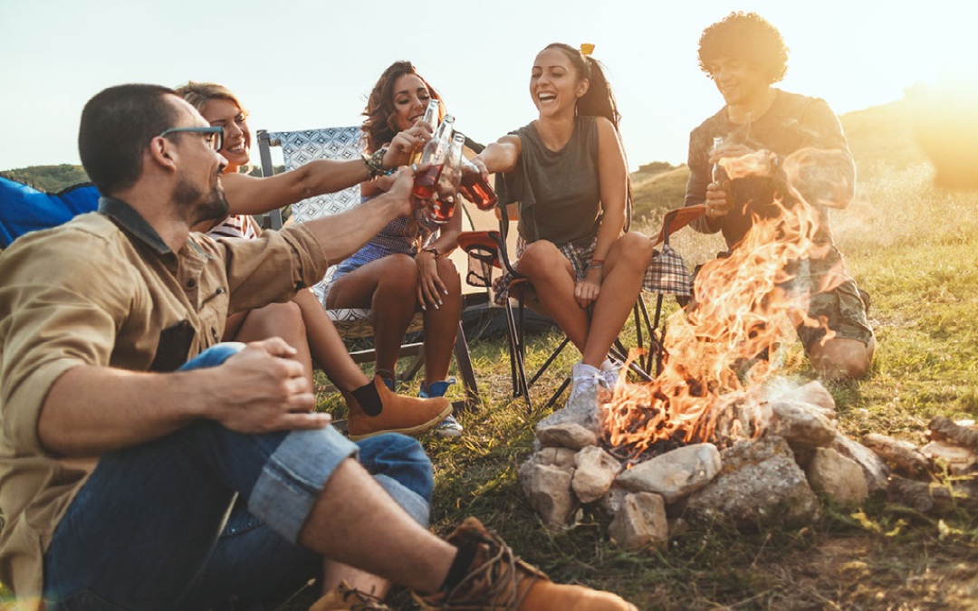 group drinking around campfire