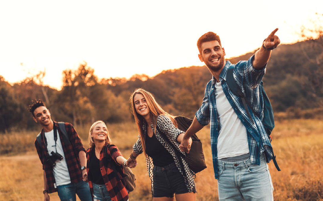 group of young adults walking forest