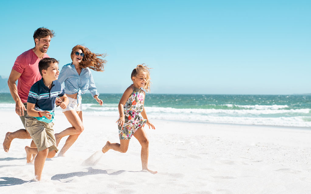 family running along beach in sunny weather
