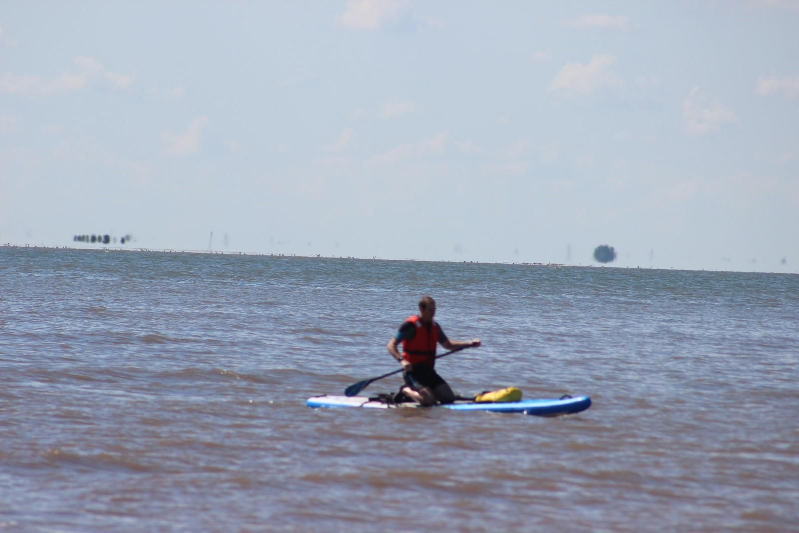 A man paddling in the sea here in Heacham on a paddleboard