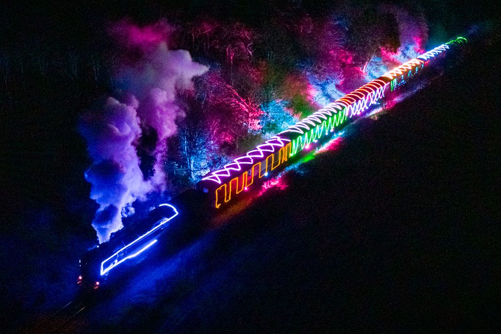 the norfolk lights express seen from above, illuminating adjacent forests