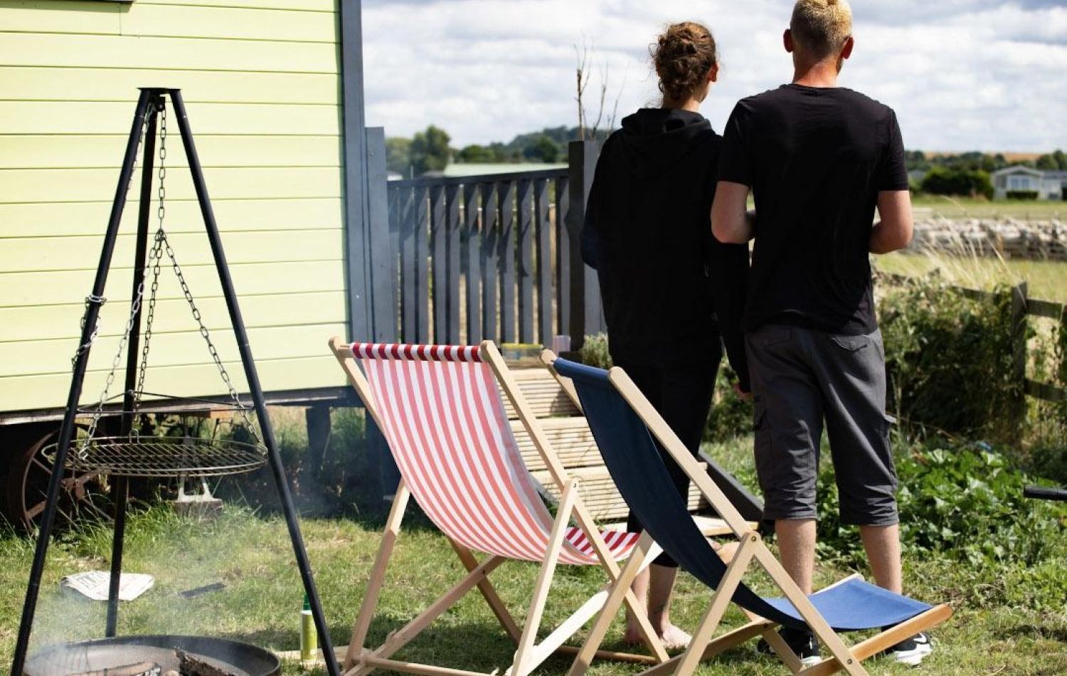 Couple looking out over a field of sheep next to a shepherd's hut