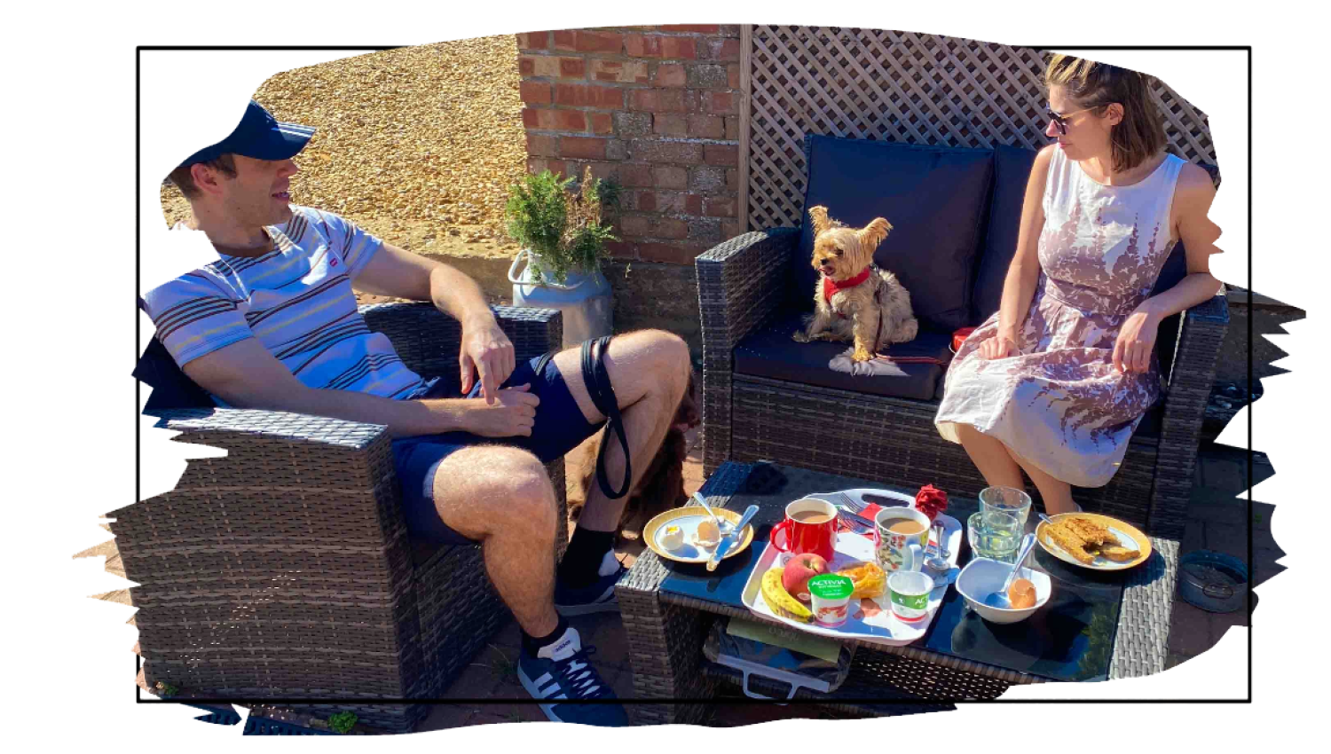 a couple eating breakfast outdoors with their dog on the norfolk coast