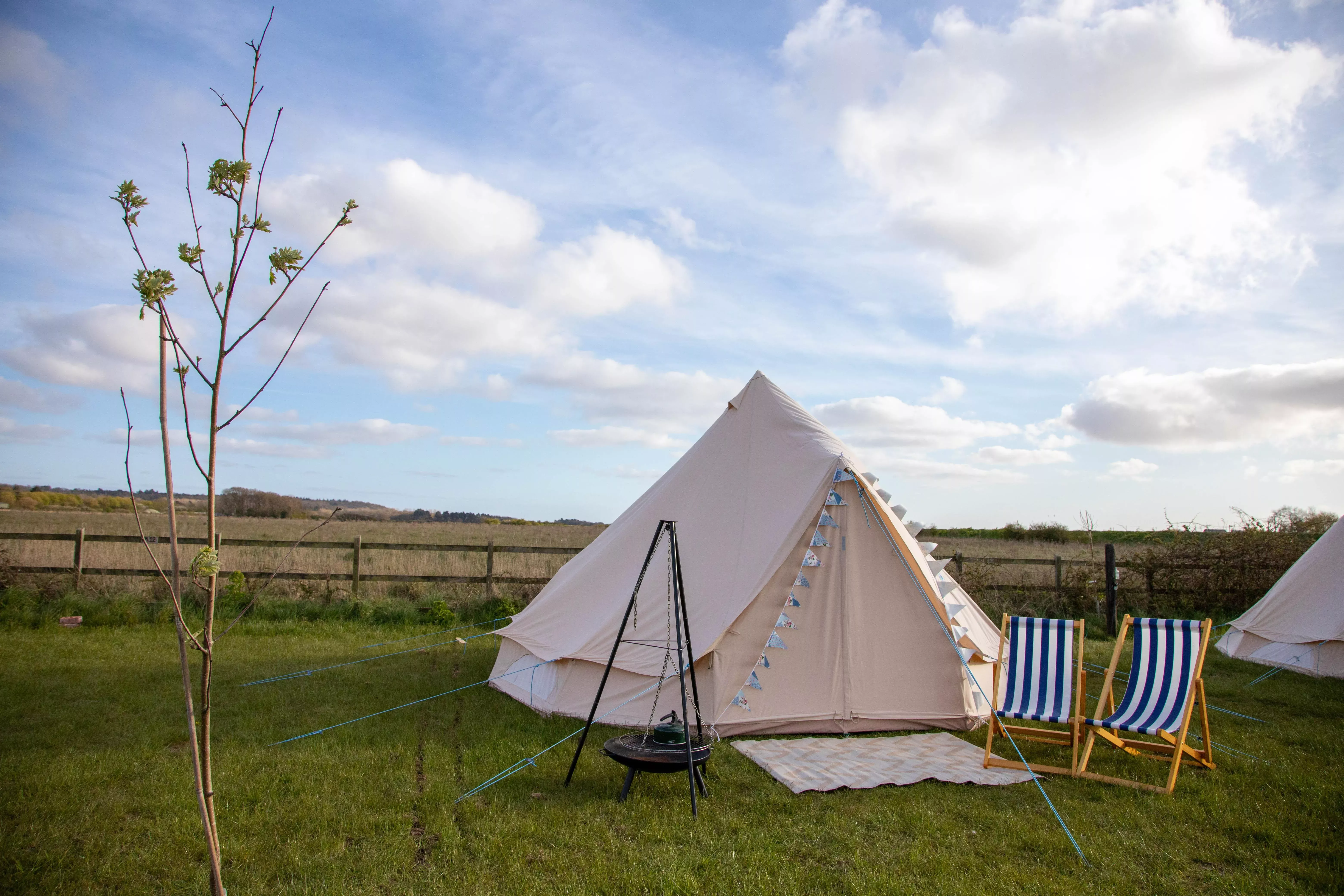 A Bell tent in wells with beautiful scenery, outdoor seating and a campfire