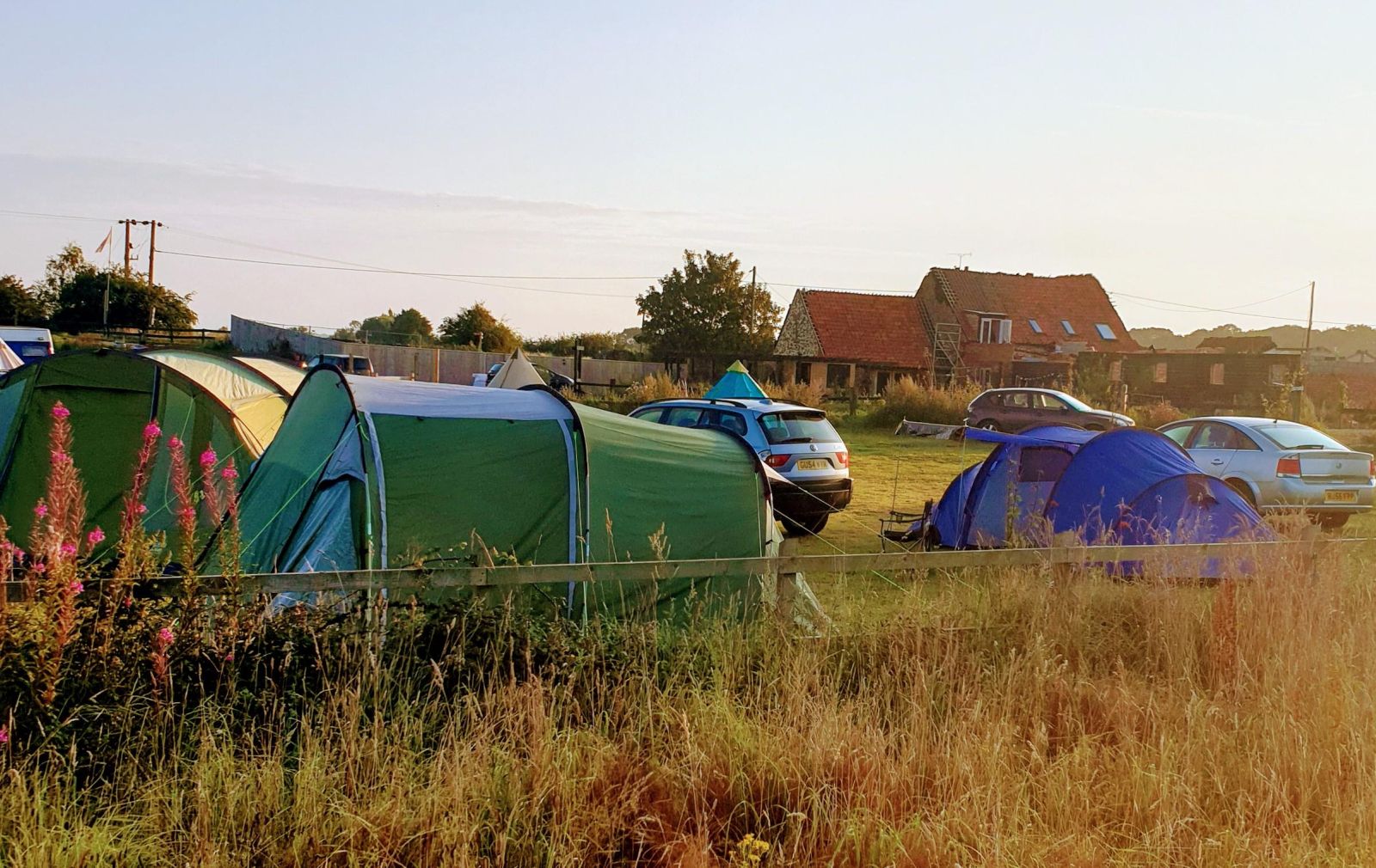 a variety of tents and cars parked onsite