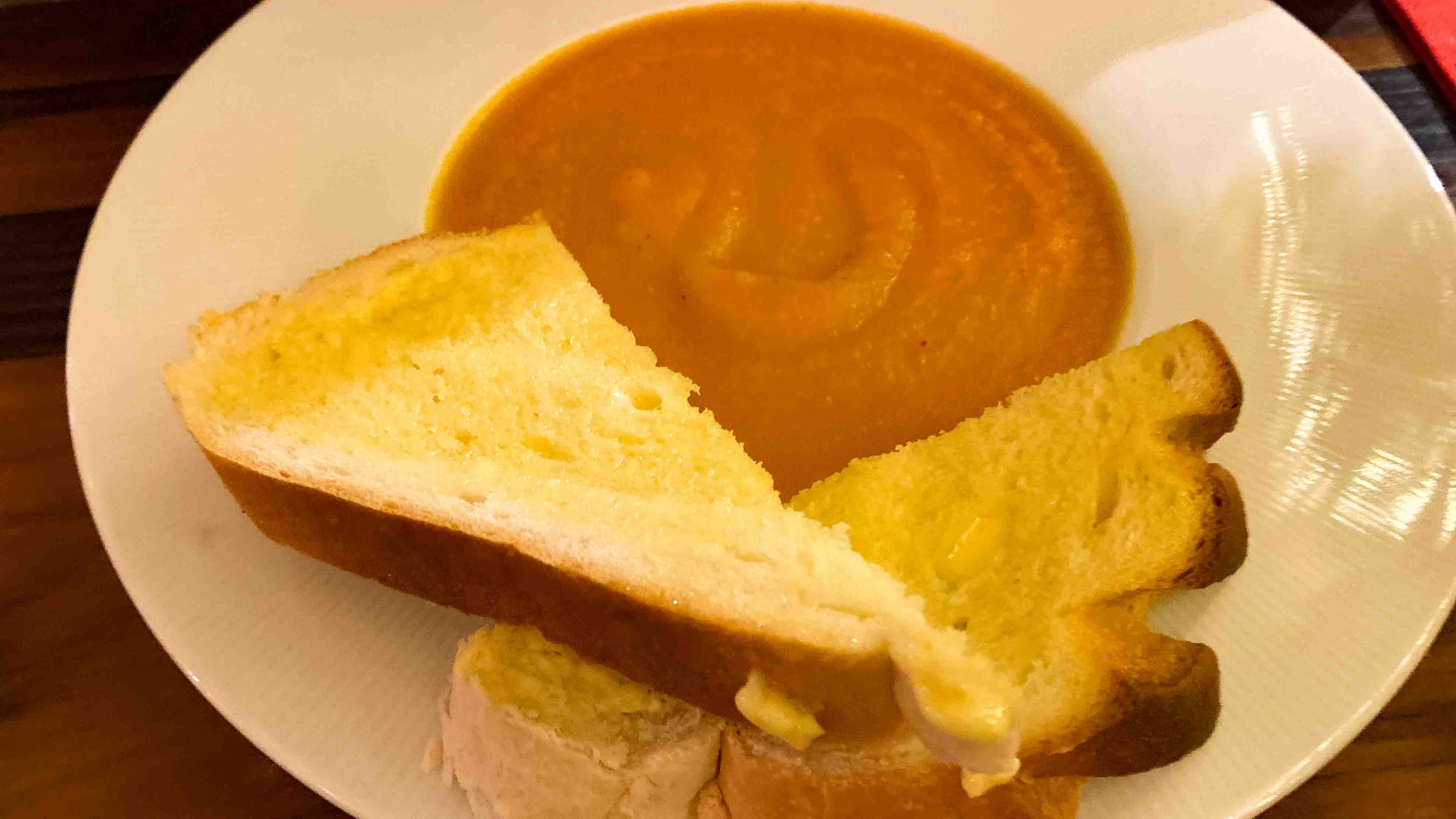 A bowl of home made vegetable soup with buttered bread