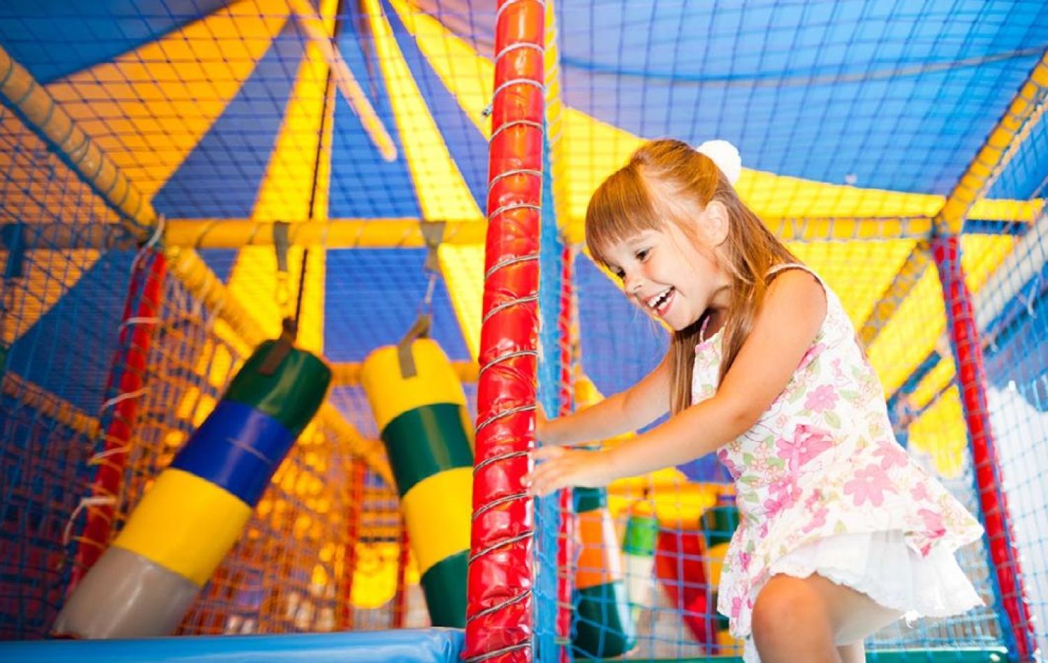 little girl running through a soft play area