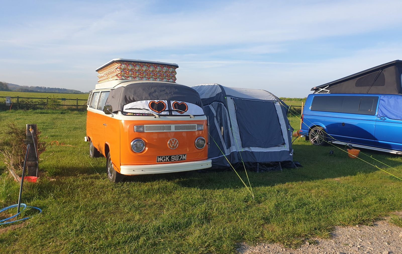 campervan with eyes and awning in a field