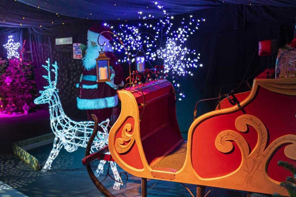santa's slay next to a lit-up reindeer and father christmas
