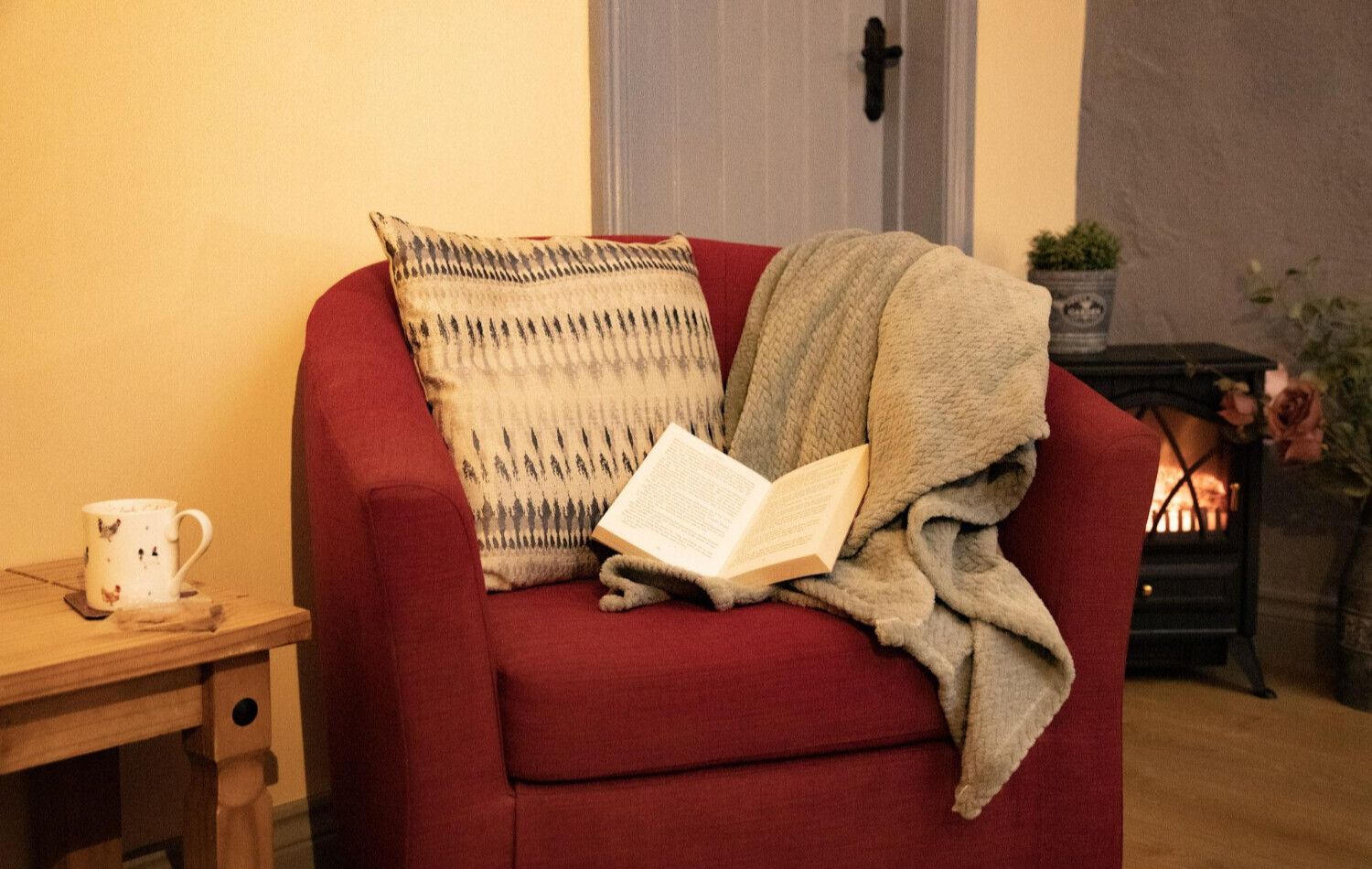 A cosy chair, blanket, and a good book by the fire
